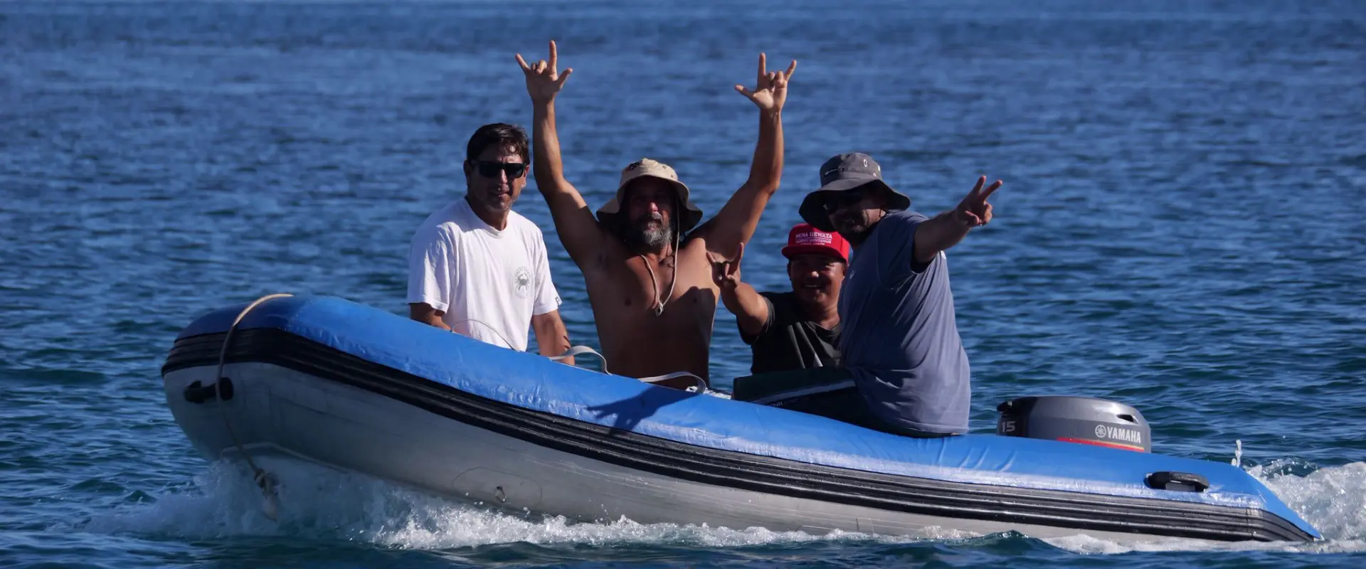 Four men cheering in a small boat