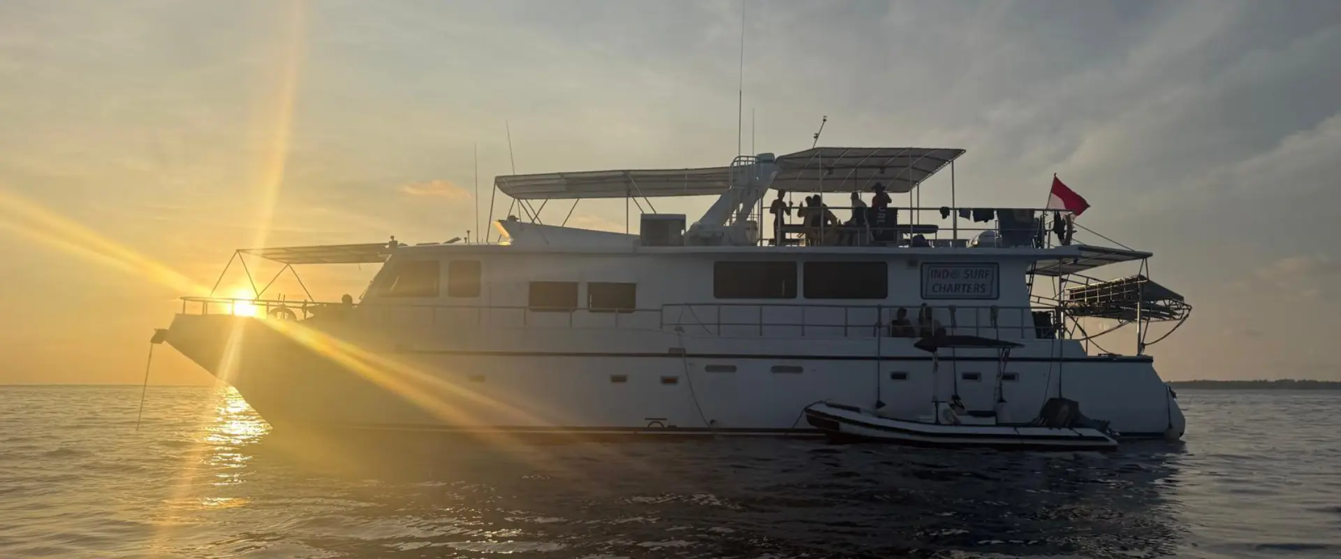 Large charter boat anchored at sea during sunset